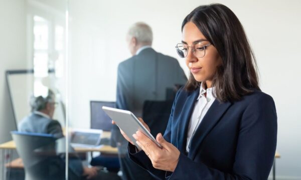 Uma mulher de negócios usando um tablet em um escritório.