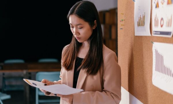 Empresária asiática olhando um documento em um escritório.
