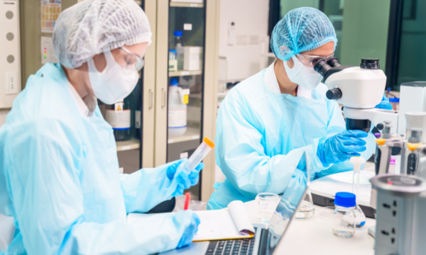 IA na indústria Farmacêutica: profissionais em laboratório realizando análises e testes com equipamentos científicos para controle de qualidade.